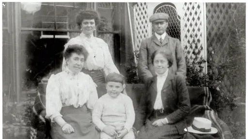Black and white image of four adults and a child wearing clothes from a previous era.
