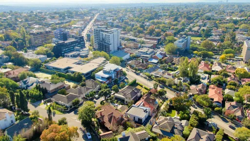 Arial view of Kew properties on a sunny day. Looking over standalone houses, highrises, and commercial buildings.