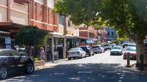 A sunny street lined with local shops.