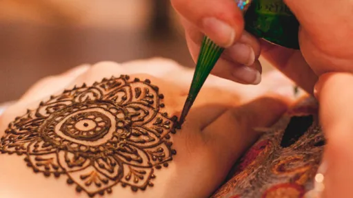 A henna design being painted on a hand.