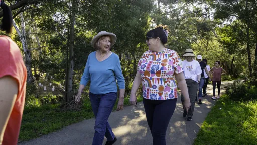 Women walking tree lined path