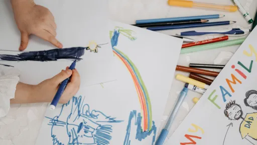 Child drawing with many coloured pencils