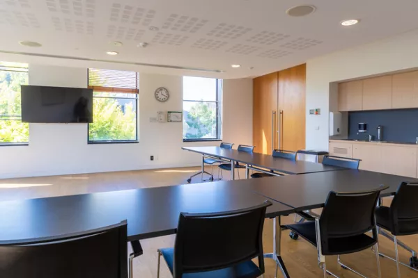 View from a meeting room table towards a wall-mounted TV