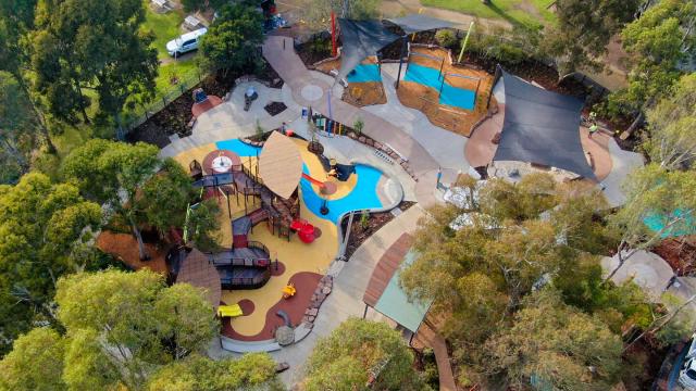 A birdeye view of a large playground surrounded by trees 