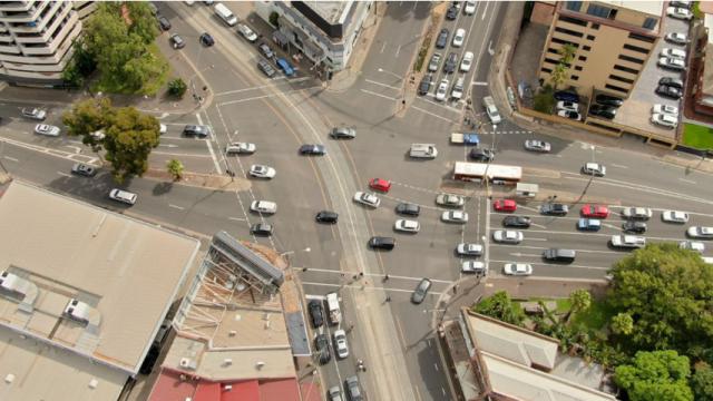 Aerial photo shows busy junction with buildings and traffic 
