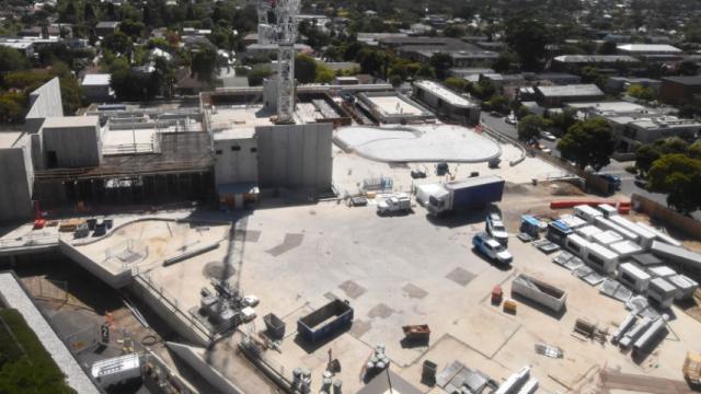 Work site with building materials, structures and vehicles