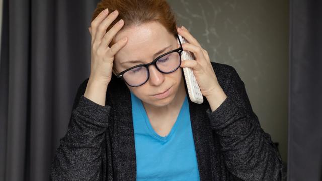 Woman looks distressed while talking on phone