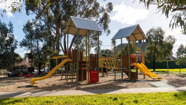 A playground with a climbing structure and slides