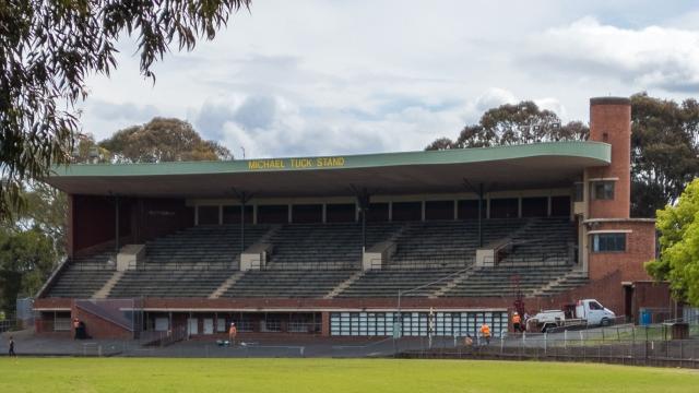 A heritage sports grandstand with signage saying Michael Tuck Stand.