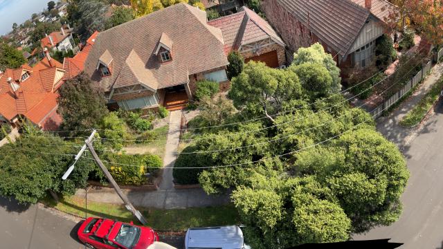 aerial panoramic image of powerlines encircling a block of houses