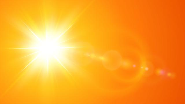 A radiantly hot sun in an orange sky