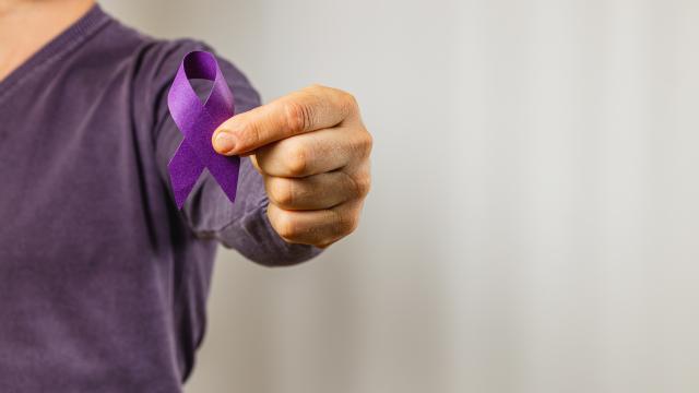 Person in purple T-shirt hold purple ribbon