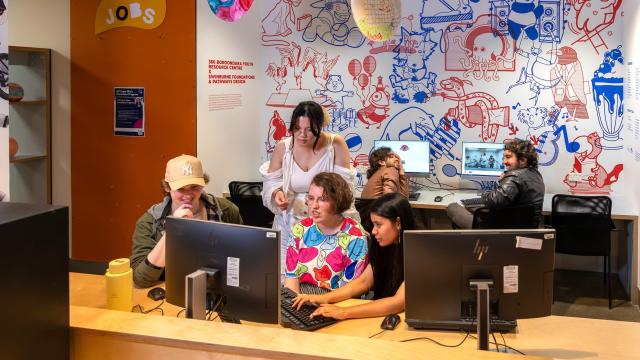Young people sitting at a computer working together.