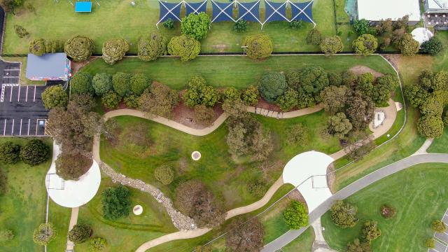 Arial view of Gordon Barnard Dog Park. A fenced area with trees, paths and difference surfaces.