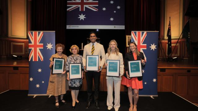 5 people standing holding Citizen of the year certificates.