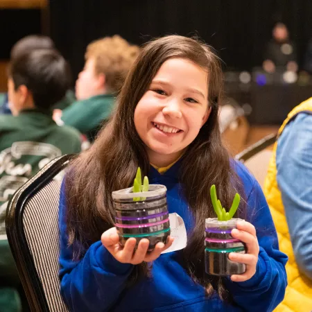 Schoolgirl holding pot plants at the Boroondara Student Sustainability Leadership Summit