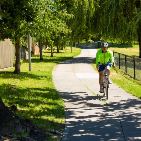 Man riding bicycle along a path.