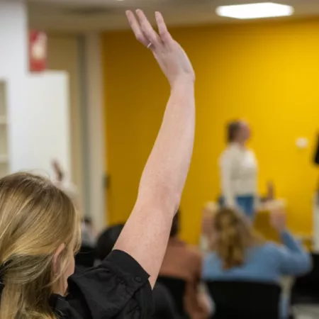 Person raising hand at public event