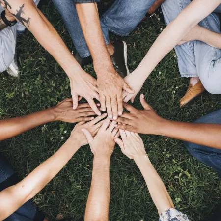 A group of people with their hands together in a circle